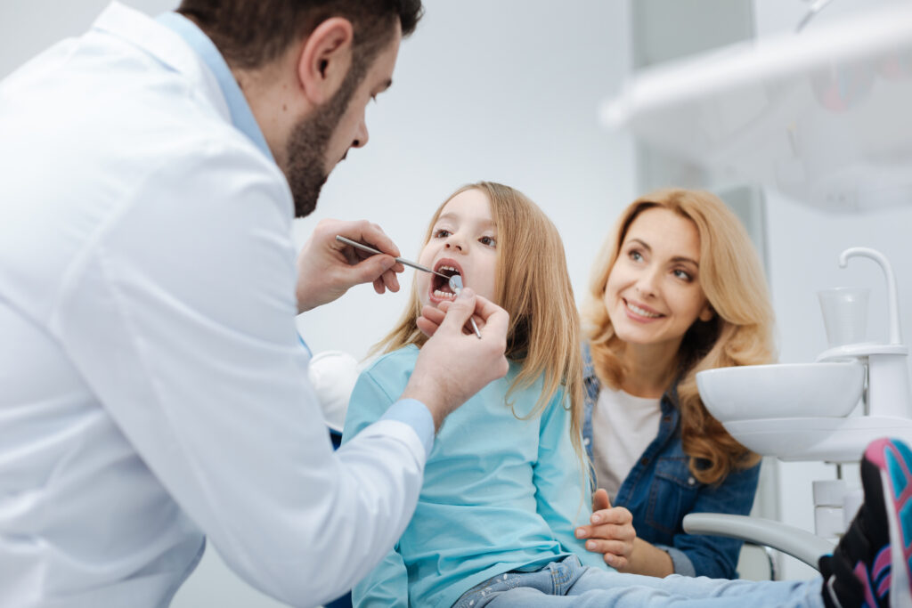 We take care of or teeth together. Caring loving great mother making sure her childs teeth being healthy by paying regular visits to doctor